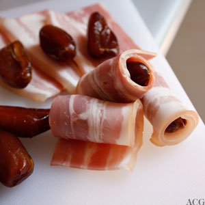 bacon rulles rundt dadlene før de stekes