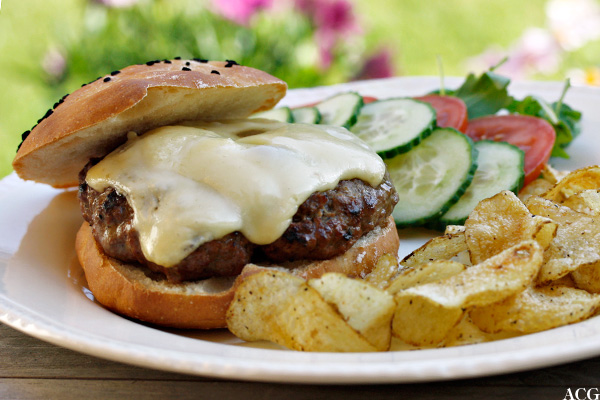 bilde av tallerken med cheeseburger , chips og grønnsaker