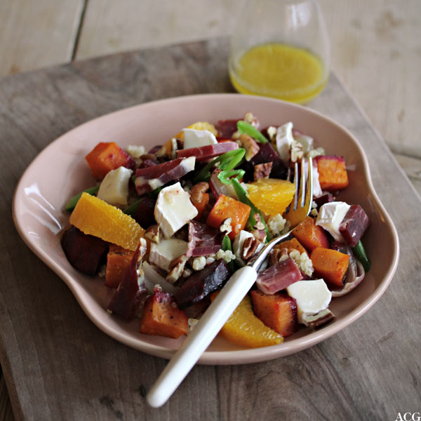 Tallerken med vintersalat og flaske med vinaigrette