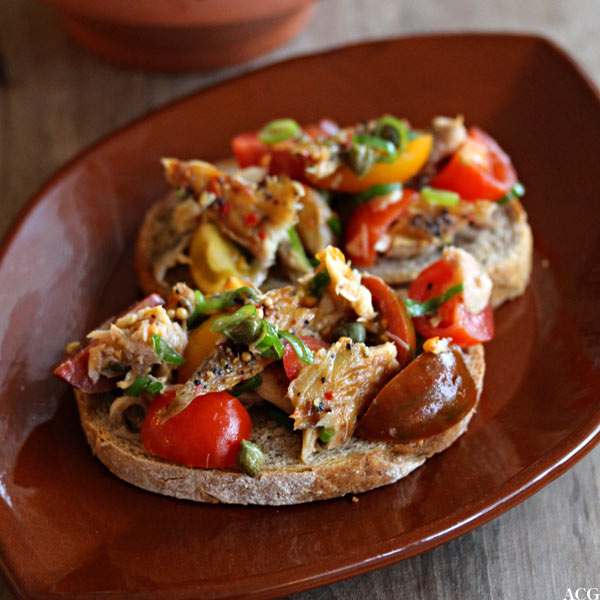 to brødskiver med makrell i tomatsalat