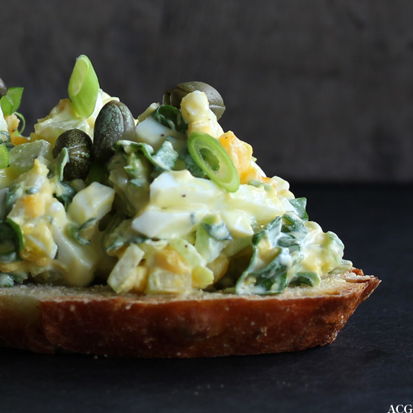 Nærbilde av skive med eggesalat og kapers